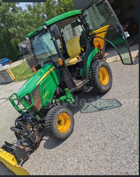 John Deere 2025R Tractor with plow blade and salt spreader