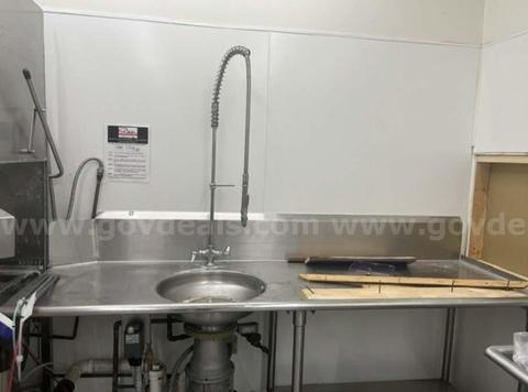 Large Sink with Sprayer and Garbage Disposal on stainless steel Counter with shelf.