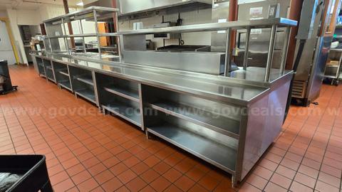 25 Foot long stainless steel prep counter with upper and lower shelves.